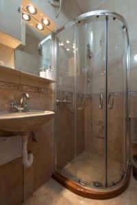 ein Bad mit einer Dusche und einem Waschbecken in der Unterkunft Sea Garden Plaza Apartment in Burgas City