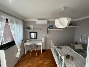 a small bedroom with a bed and a desk and a window at Villa ZöldFüge in Balatonfůzfő