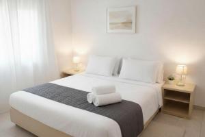 a bedroom with a large white bed with two lamps at Yviome Rhodes Central Escape in Rhodes Town