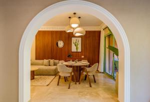 an archway leads into a living room with a table and a couch at Luxury Apartment with Private Jacuzzi & Pool Central Marrakech in Marrakesh