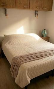 a large bed in a bedroom with at Veluwe Droom Chalet in Hoenderloo