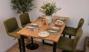 a wooden table with chairs and plates and wine glasses at Veluwe Droom Chalet in Hoenderloo