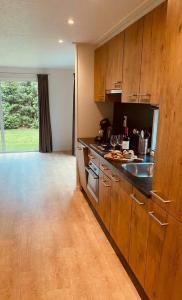 a kitchen with wooden cabinets and a counter top at Veluwe Droom Chalet in Hoenderloo