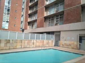a swimming pool in front of a building at Durban Oceanic Apartment 82B in Durban