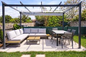 a patio with a couch and a table and chairs at Herama Sea Guesthouse in Vila Nova de Gaia