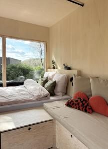 a bedroom with two beds and a large window at Tiny House 1 mit Garten in der Lüneburger Heide in Soltau