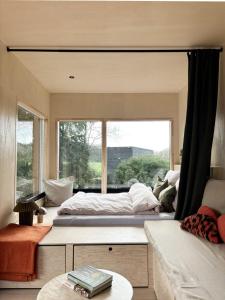 a bedroom with a bed and a large window at Tiny House 1 mit Garten in der Lüneburger Heide in Soltau