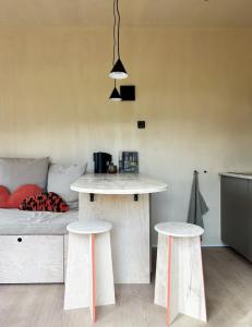 a living room with two stools and a table at Tiny House 1 mit Garten in der Lüneburger Heide in Soltau +18 photos
