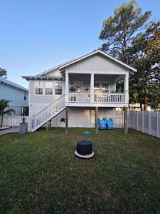 a house with a porch and a hat on the lawn at Pelican's Perch in Santa Rosa Beach