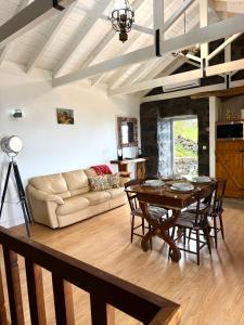 a living room with a table and a couch at Bruma do Pico House in Lajes do Pico
