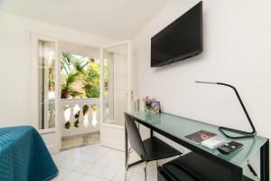 a room with a desk and a television on a wall at Muta House in Sorrento