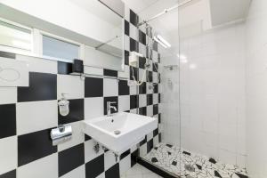 a bathroom with a sink and a black and white checkered wall at Muta House in Sorrento +74 photos