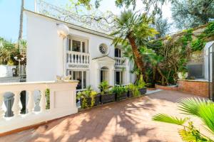 a white house with a staircase and palm trees at Muta House in Sorrento