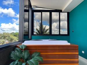 a bedroom with a large window with a bed and a plant at Residencial Canto dos Passarinhos - Loft e Apartamentos in Alto Paraíso de Goiás