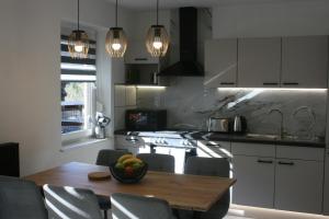 a kitchen with a table with a bowl of fruit on it at Mountain View Mojstrana in Mojstrana
