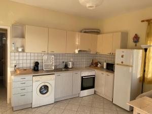a kitchen with white cabinets and a washer and dryer at michelangela in Ireon