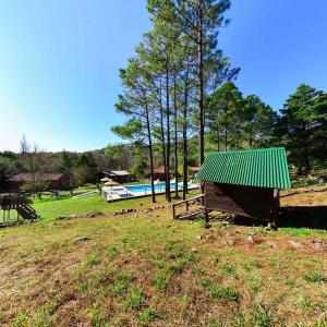 een gebouw met een groen dak in een veld bij Pinar del Arroyito in Villa General Belgrano