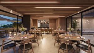 a restaurant with wooden tables and chairs and windows at Apartamento de Luxo 2 Quartos, Brasília - Get Park Sul - com Garagem in Brasília