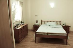 a bedroom with a bed and a dresser and a window at Flat Mimmo in Praia