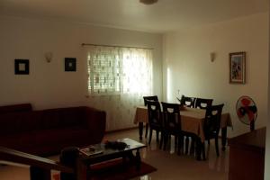 a living room with a couch and a table with chairs at Flat Mimmo in Praia +22 photos