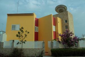 a yellow and red building next to a fence at Flat Mimmo in Praia