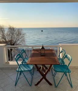 a wooden table and chairs on a balcony overlooking the water at michelangela in Ireon