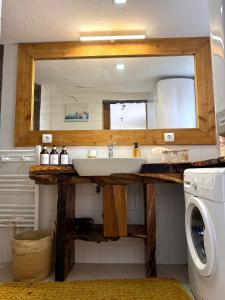 a bathroom with a sink and a washing machine at Bruma do Pico House in Lajes do Pico