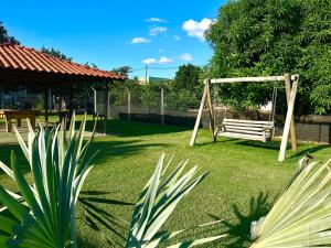 a park with a swing in the grass at Hotel & Pousada Recanto do Sabiá in Pirapora