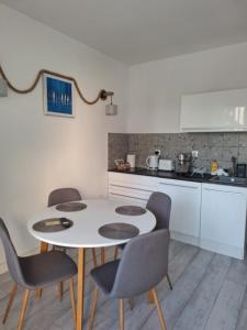 a kitchen with a white table and chairs at Apartment DESi in Balchik