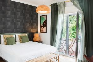 a bedroom with a bed and a large window at Chitaka's Organic Farmhouse in Ribatejo in Santo Estêvão +64 photos