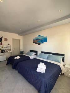 two beds in a bedroom with blue sheets and towels at La casa di Fiore in Vico Equense