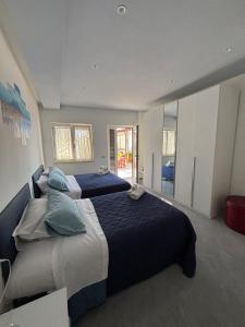 a large bedroom with two beds with blue pillows at La casa di Fiore in Vico Equense