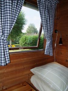 a bedroom with a bed and a window with curtains at dieSeeSucht - Lodge am Fjord in Westerholz