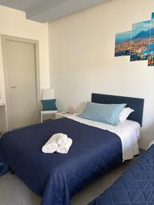 a bedroom with a blue bed with towels on it at La casa di Fiore in Vico Equense