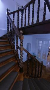 a wooden staircase with black railings in a house at Vila Rapsodia Sinaia in Sinaia