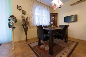 a dining room with a table and black chairs at Sea Garden Plaza Apartment in Burgas