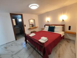 a bedroom with a large bed with a red blanket at Irene' s Paradise in Skopelos Town