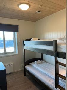 two bunk beds in a room with a window at Affordable Luxury Sauna Chalet - River Views in Vossevangen