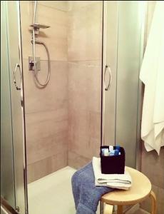 a bathroom with a shower with a table and a stool at Palladio B&B in Gela