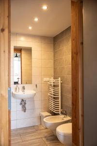 a bathroom with a sink and a toilet and a sink at Apartamenty Doliny in Szczyrk +91 photos