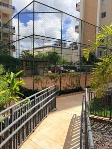 a chain link fence with a walkway in front of a building at JUPET Studio in Brasília