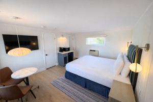 a bedroom with a bed and a table and chairs at The Foxberry - A Digital Concierge Guesthouse in Provincetown