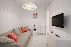 a living room with a couch and a flat screen tv at La casa di Sally - Silenzioso Bilocale in centro in Trieste