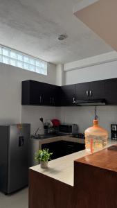 a kitchen with black cabinets and a wooden counter top at Suite Privada Moderna in Santa Ana Chiautempan