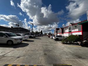 a parking lot with a lot of cars parked at Broadway Inn Motel in Los Angeles