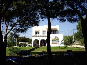 a white house with trees and chairs in front of it at Finca Malyma with 2 villas and 1 apartment, beach front 10,000m2 botanic garden in Zahora