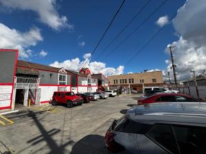 a parking lot with cars parked in front of a building at Broadway Inn Motel in Los Angeles