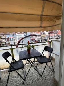 a table and two chairs on a balcony at Spring Studio Apartment in Prizren +2 photos