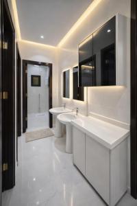 a white bathroom with two sinks and a shower at الشقق الفاخرة luxury aparments in Medina +11 photos