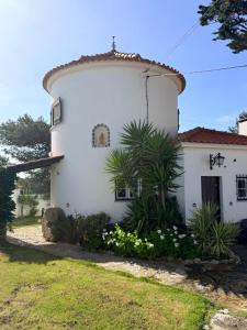 a white house with flowers in front of it at Moinho da Saudade in Alcabideche
